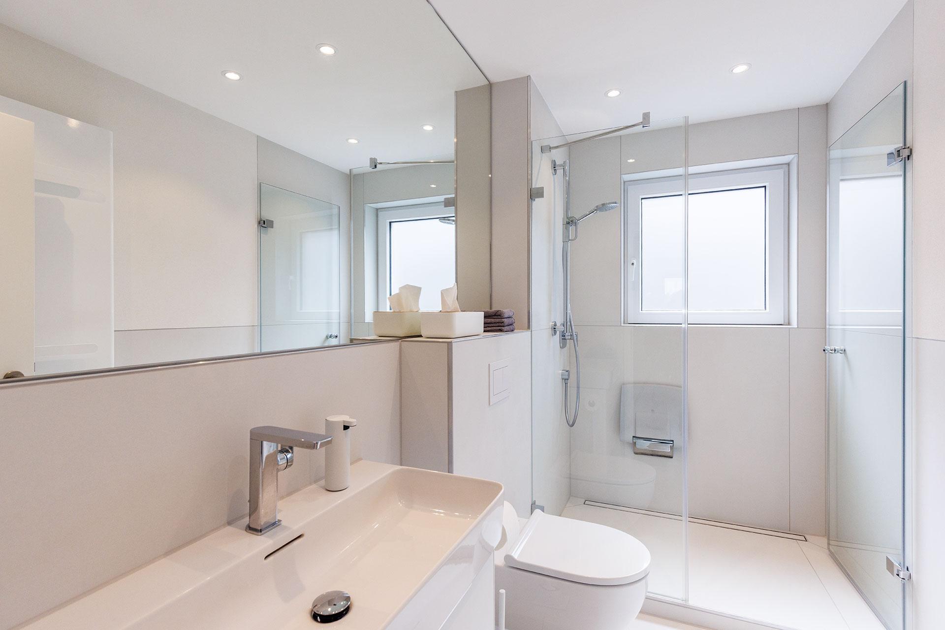 Modernes Badezimmer mit Glasdusche, WC und Waschtisch