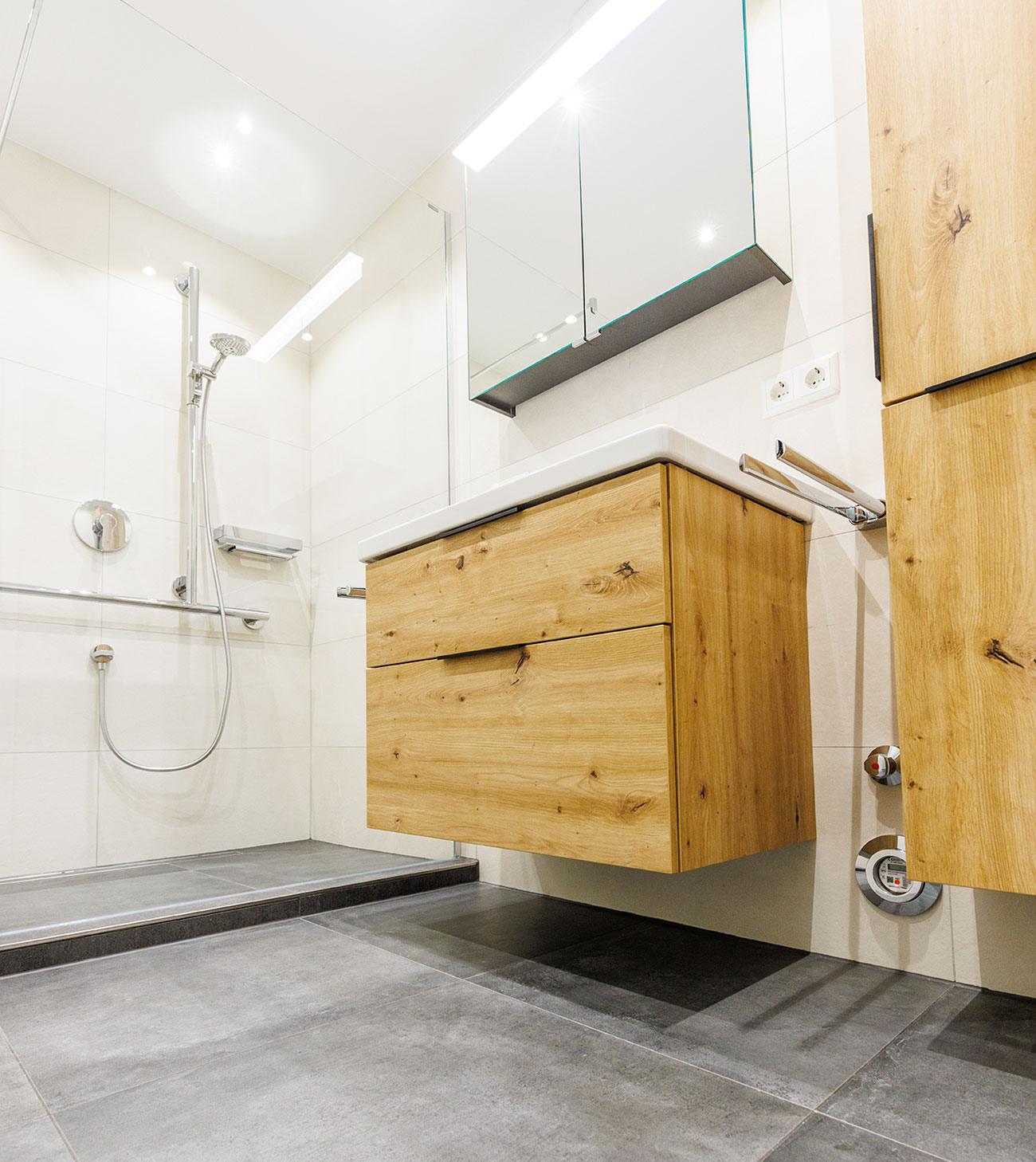 Kleines Badezimmer mit bodengleicher Dusche und Badmöbeln in Holzoptik